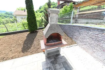 a stone fireplace sitting on top of a patio at Sobe - Rooms Drvorez in Banja Luka