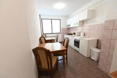 a small kitchen with a wooden table and chairs at Sobe - Rooms Drvorez in Banja Luka