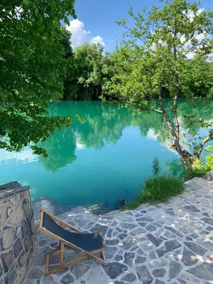 a bench sitting in front of a lake at Kuća za odmor KRNJAIĆ,porodični KAMP in Bosanski Novi
