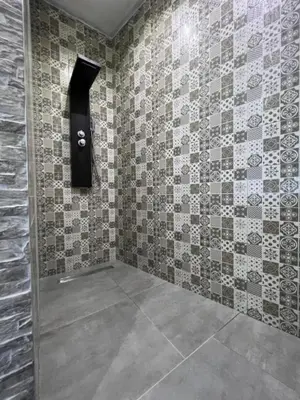 a bathroom with a tiled wall with a blackigunigunigun at Hotel Central Vlašić in Vlasic