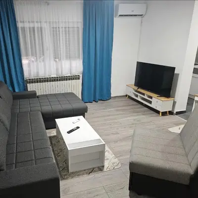 a living room with a couch and a tv at Apartman u centru Prnjavor in Prnjavor