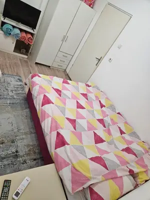a quilt laying on a bed in a room at Apartman u centru Prnjavor in Prnjavor
