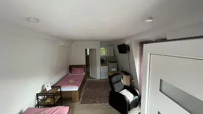 a small room with a bed and a chair at City apartment 3 in Visoko