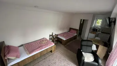 a small room with two beds and a chair at City apartment 3 in Visoko