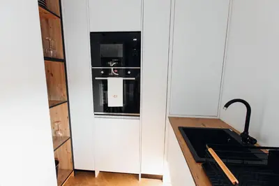 a kitchen with a white cabinet with a stove at Stan na dan - Chic Home Banja Luka in Banja Luka