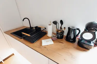 a counter top with a stove and utensils on it at Stan na dan - Chic Home Banja Luka in Banja Luka