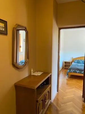 a room with a table and a mirror and a bed at Apartman Lavanda in Drvar