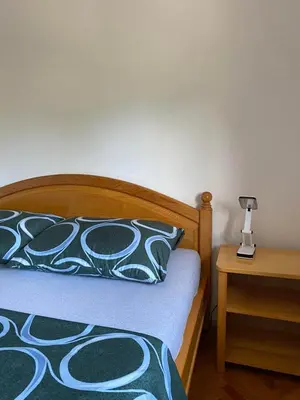 a bedroom with a bed and a lamp on a table at Apartman Lavanda in Drvar