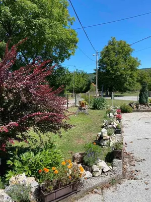 a garden with flowers and rocks on a street at Apartman Lavanda in Drvar