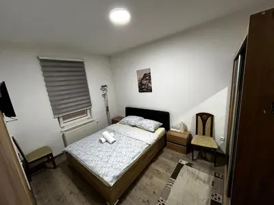 a bedroom with a bed and a chair in it at Apartmani Venci Travnik in Travnik