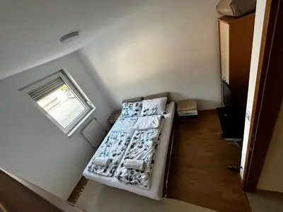 a small room with two beds and a window at Apartmani Venci Travnik in Travnik