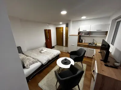 a bedroom with a bed and a table and chairs at Apartmani Venci Travnik in Travnik