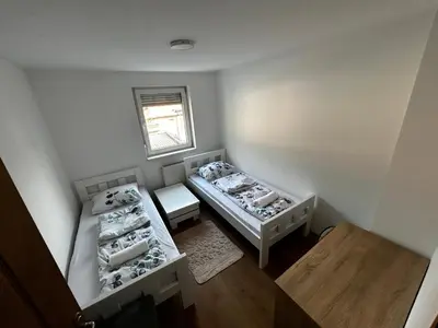 a small room with two beds and a window at Apartmani Venci Travnik in Travnik