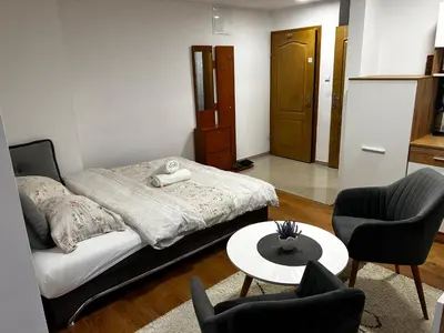 a bedroom with a bed and two chairs and a table at Apartmani Venci Travnik in Travnik