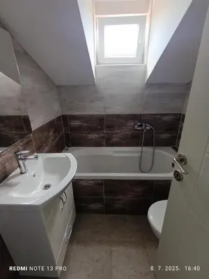 a bathroom with a sink and a tub and a toilet at Apartmani Kula in Tuzla