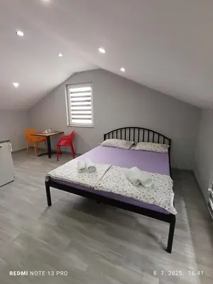 a bedroom with a bed with purple sheets and a table at Apartmani Kula in Tuzla