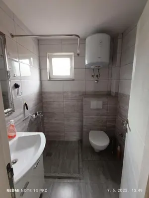 a small bathroom with a toilet and a sink at Apartmani Kula in Tuzla