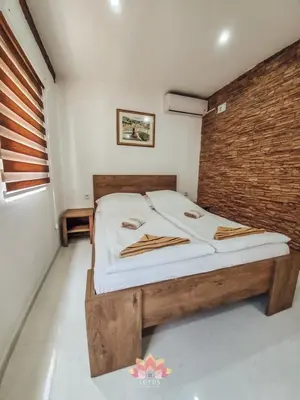a bedroom with a bed with a wooden headboard at Holiday home LOTUS in Bihać