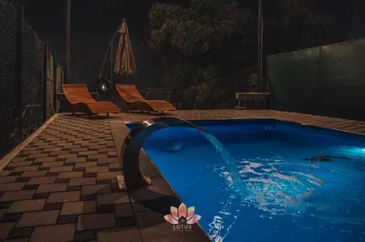 a swimming pool at night with two chairs at Holiday home LOTUS in Bihać