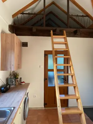 a wooden ladder in a kitchen with a loft at Mountain Heart House in Bosanski Petrovac