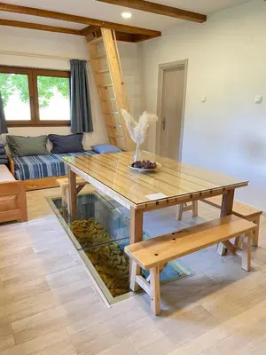 a wooden table and bench in a living room at Mountain Heart House in Bosanski Petrovac
