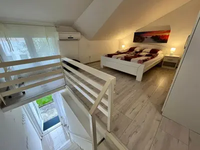 a bedroom with a bed and a staircase in it at Stan Centar 1 in Banja Luka