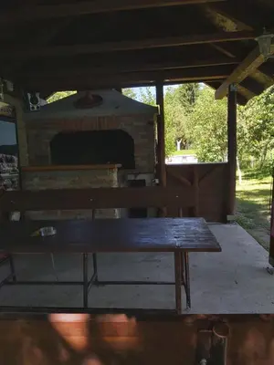 a wooden bench sitting in front of a brick oven at Šadrvan Una Apartment in Bihać