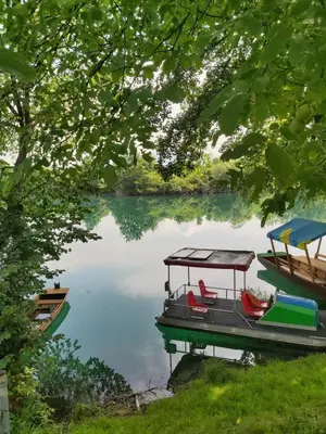 a boat on a lake with two chairs on it at Šadrvan Una Apartment in Bihać