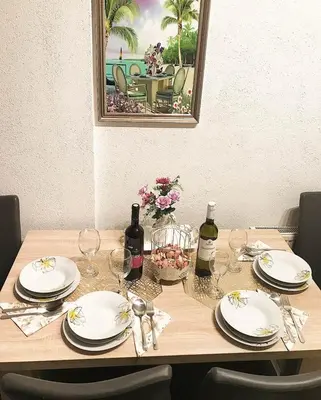 a wooden table with plates and wine glasses on it at Apartman Dunja II in Prijedor
