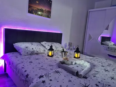 a bedroom with a bed with lights on it at Apartman Dunja II in Prijedor
