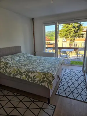 a bedroom with a bed and a view of a balcony at Urban Home Visoko in Visoko