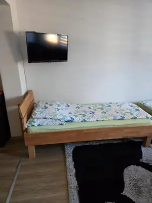 a bedroom with a bed with a flat screen tv on the wall at Urban Home Visoko in Visoko