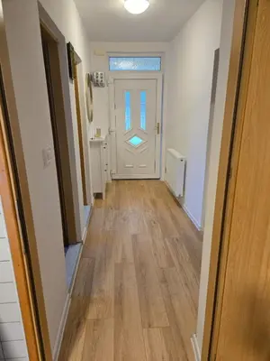 an empty hallway with a white door and wooden floors at Urban Home Visoko in Visoko
