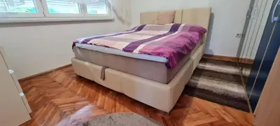 a bed in a room with a wooden floor at Urban Home Visoko in Visoko