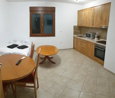 a kitchen with a table and chairs and a table and a tablektop at Apartmani Kuprešak in Banja Vrućica