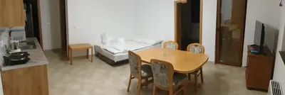 a dining room with a table and chairs and a bedroom at Apartmani Kuprešak in Banja Vrućica