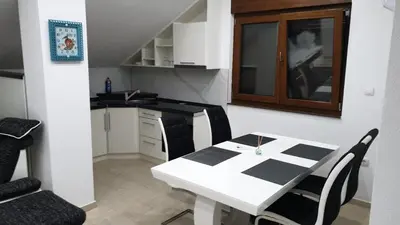 a white table and chairs in a small kitchen at Apartmani Kuprešak in Banja Vrućica