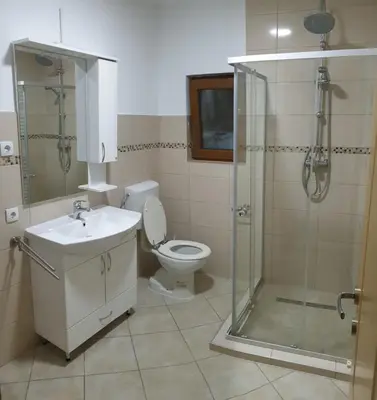 a bathroom with a toilet and a shower and a sink at Apartmani Kuprešak in Banja Vrućica