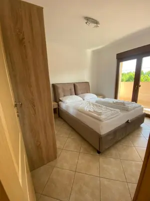 a bedroom with a bed and a sliding door at Apartmani Kuprešak in Banja Vrućica