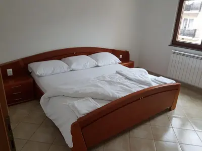 a bed with white sheets and pillows in a bedroom at Apartmani Kuprešak in Banja Vrućica
