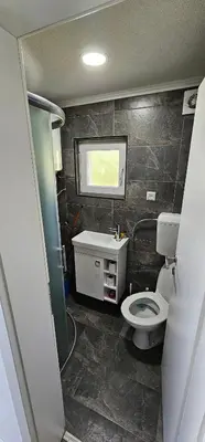 a small bathroom with a toilet and a sink at Apartmani Roki in Tuzla
