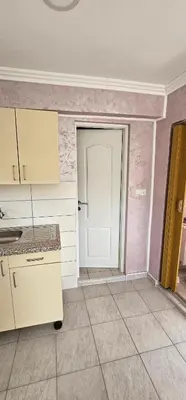 an empty kitchen with a white door in a room at Apartmani Roki in Tuzla