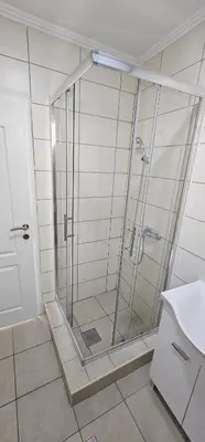 a shower with a glass door in a bathroom at Apartmani Roki in Tuzla