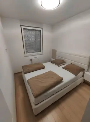 a bedroom with a large bed and a window at Apartman SLOL in Banja Luka