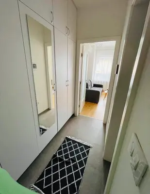 a hallway with a mirror and a black and white rug at Apartment HOLIDAY in Banja Luka