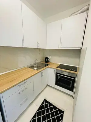 a small kitchen with white cabinets and a sink at Apartment HOLIDAY in Banja Luka
