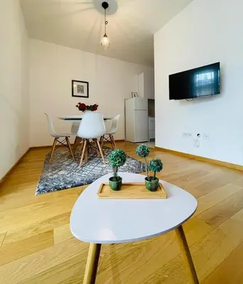 a living room with a table and chairs and a kitchen at Apartment HOLIDAY in Banja Luka