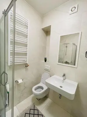 a white bathroom with a toilet and a sink at Apartment HOLIDAY in Banja Luka
