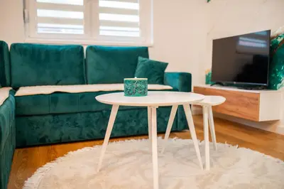 a coffee table in a living room with a couch at Apartment Vila Idila in Tuzla