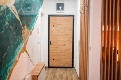a wooden door in a hallway with a table at Apartment Vila Idila in Tuzla